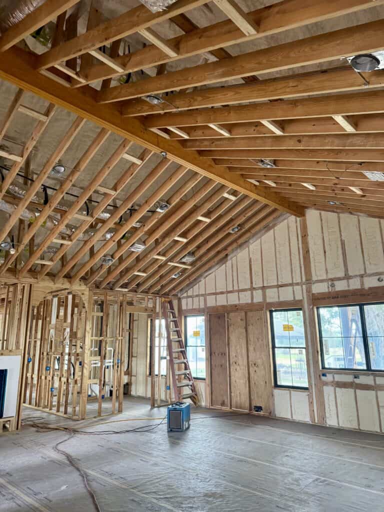Spray foam insulation installation in a new home construction for improved energy efficiency.