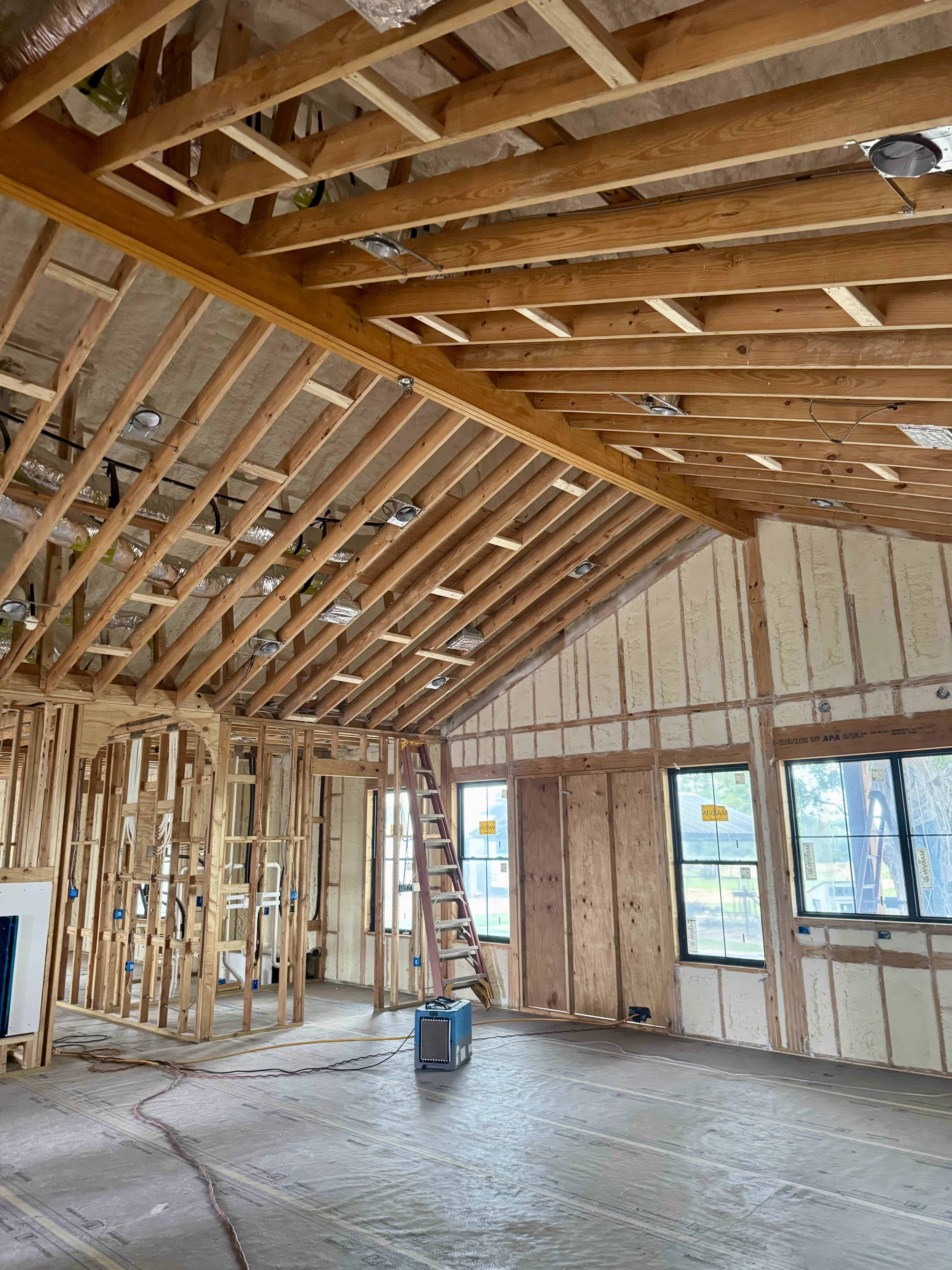 Spray foam insulation installation in a new home construction for improved energy efficiency.