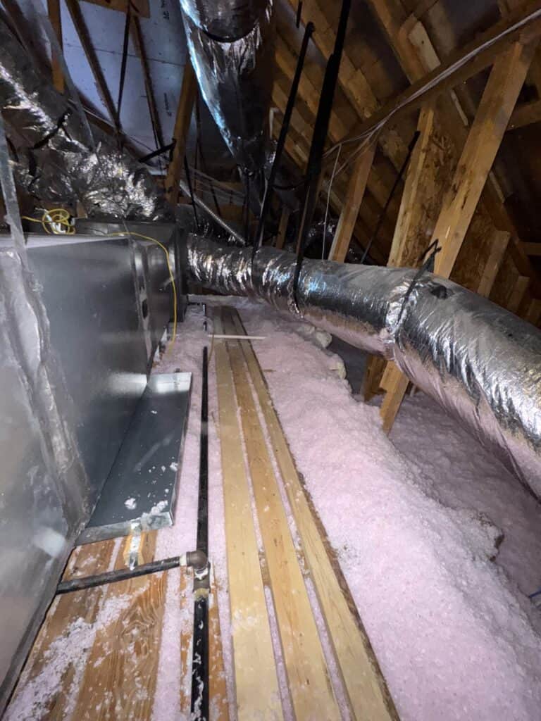 Attic insulation with blown-in fiberglass under decking.