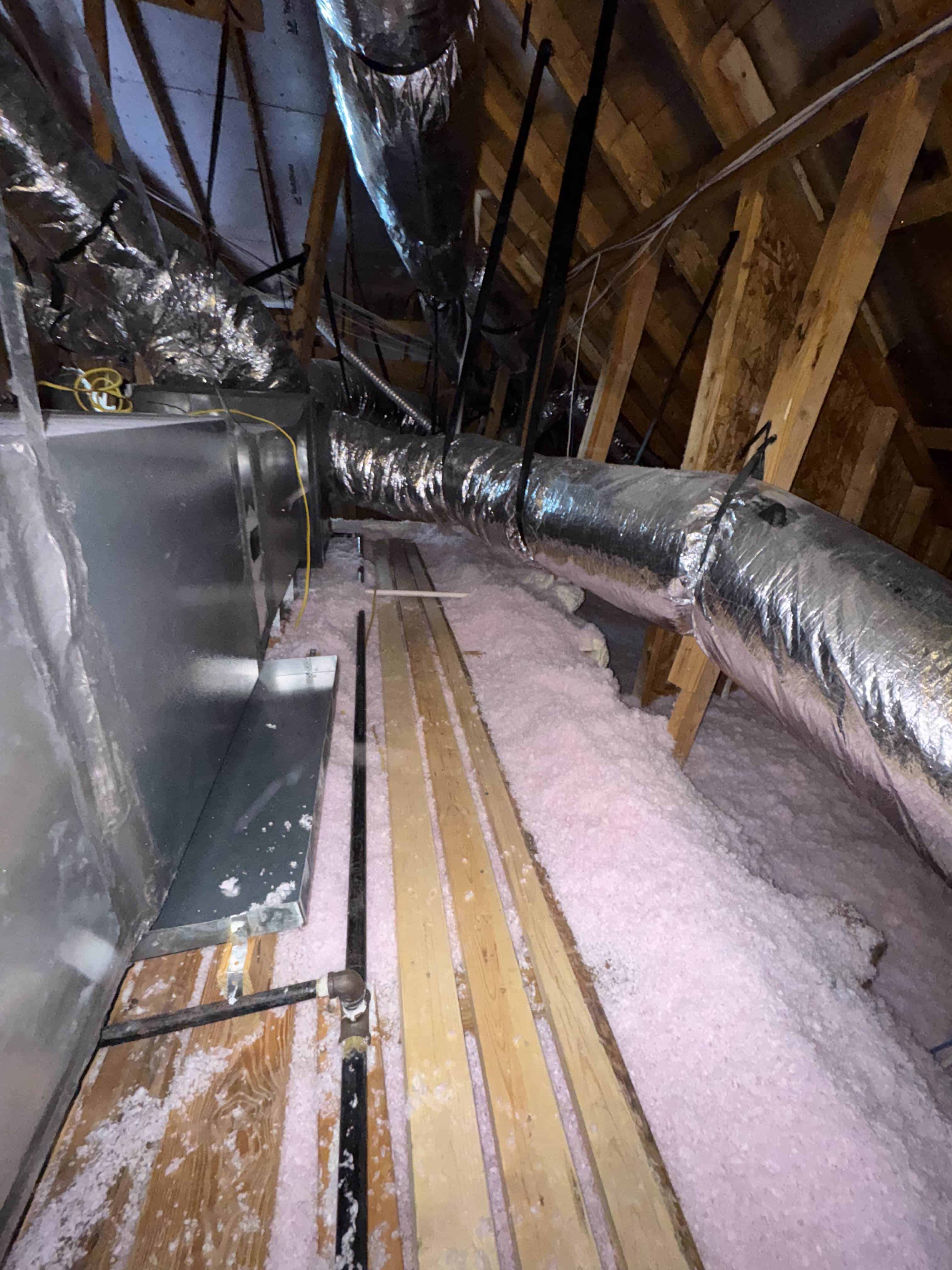 Attic insulation with blown-in fiberglass under decking.