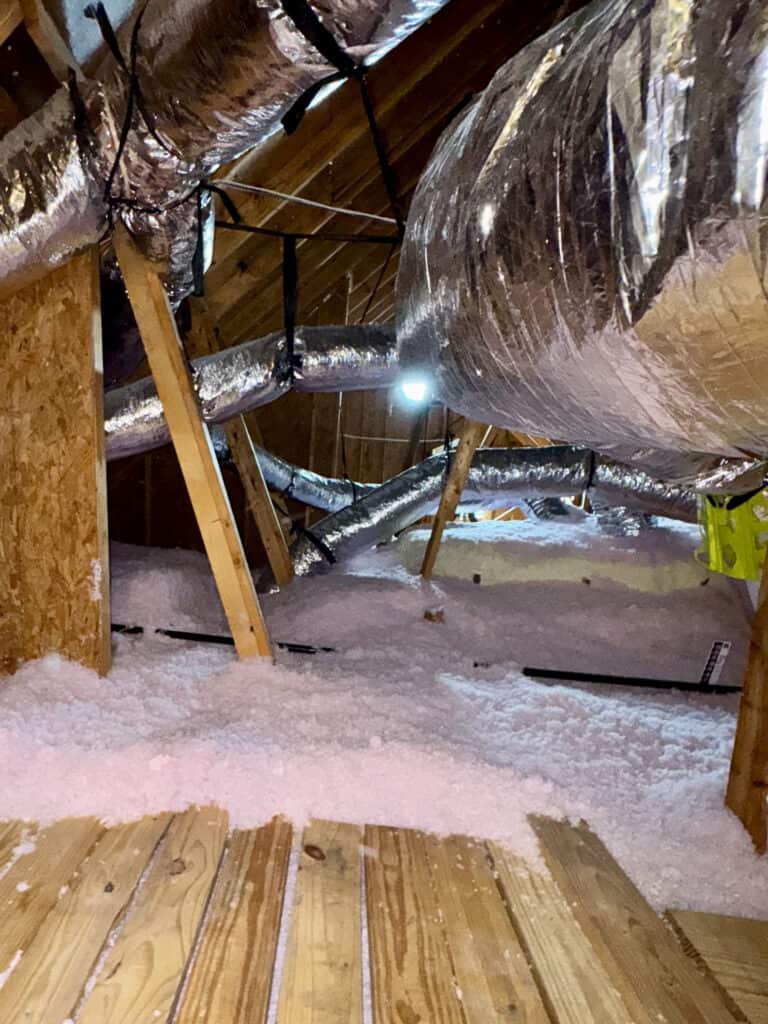 Attic insulation and ductwork in a residential attic space.