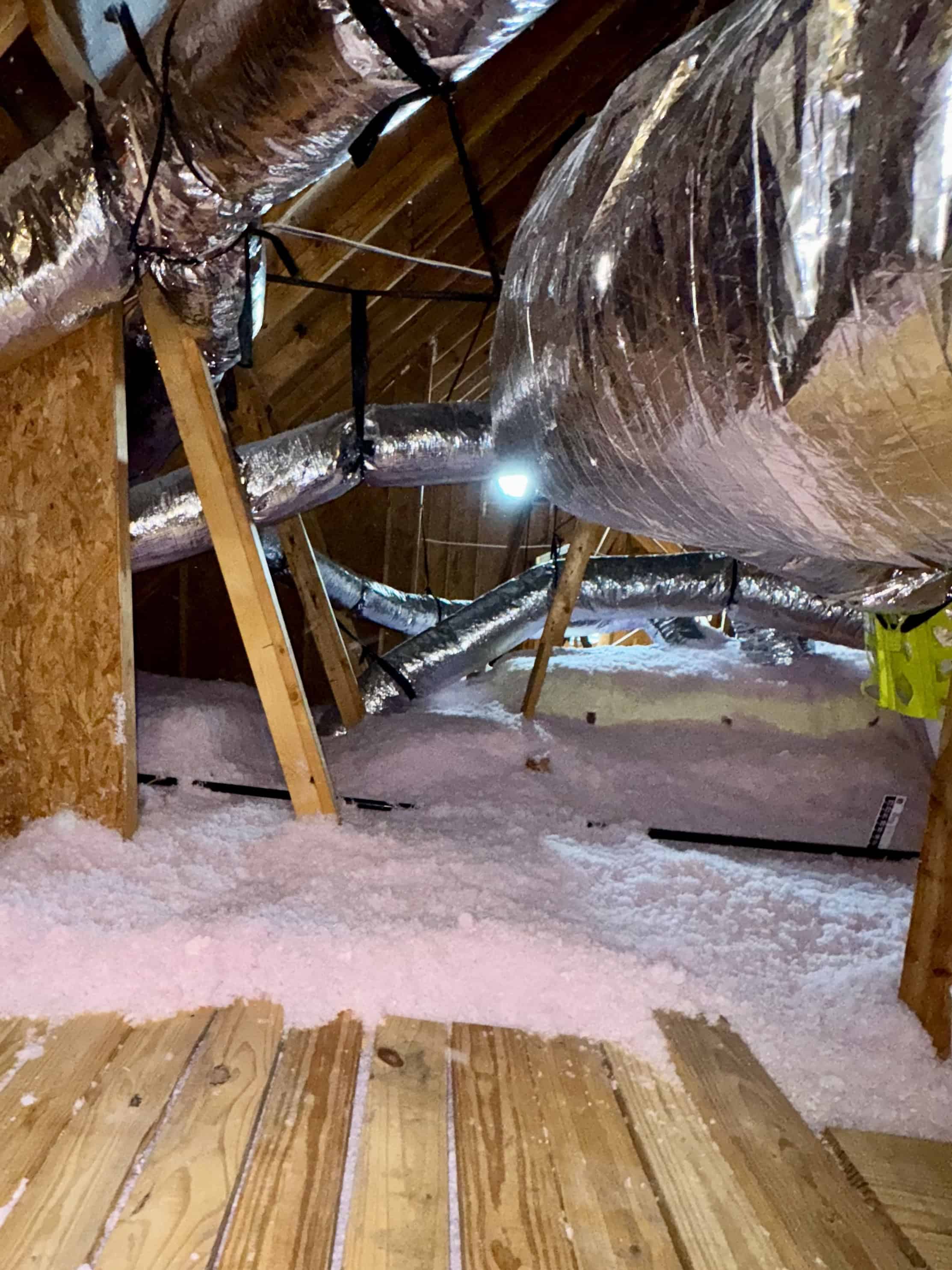 Attic insulation and ductwork in a residential attic space.
